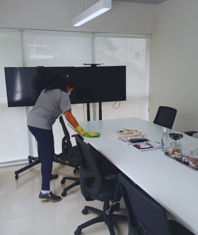 Profissional de limpeza terceirizada higienizando escritório em Santa Catarina