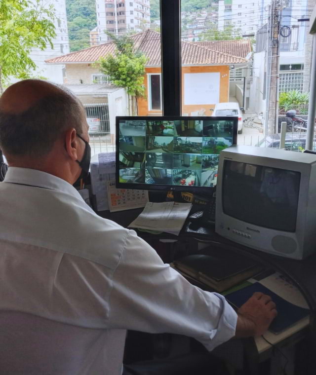 Imagem de porteiro realizando monitoramento de segurança em portaria